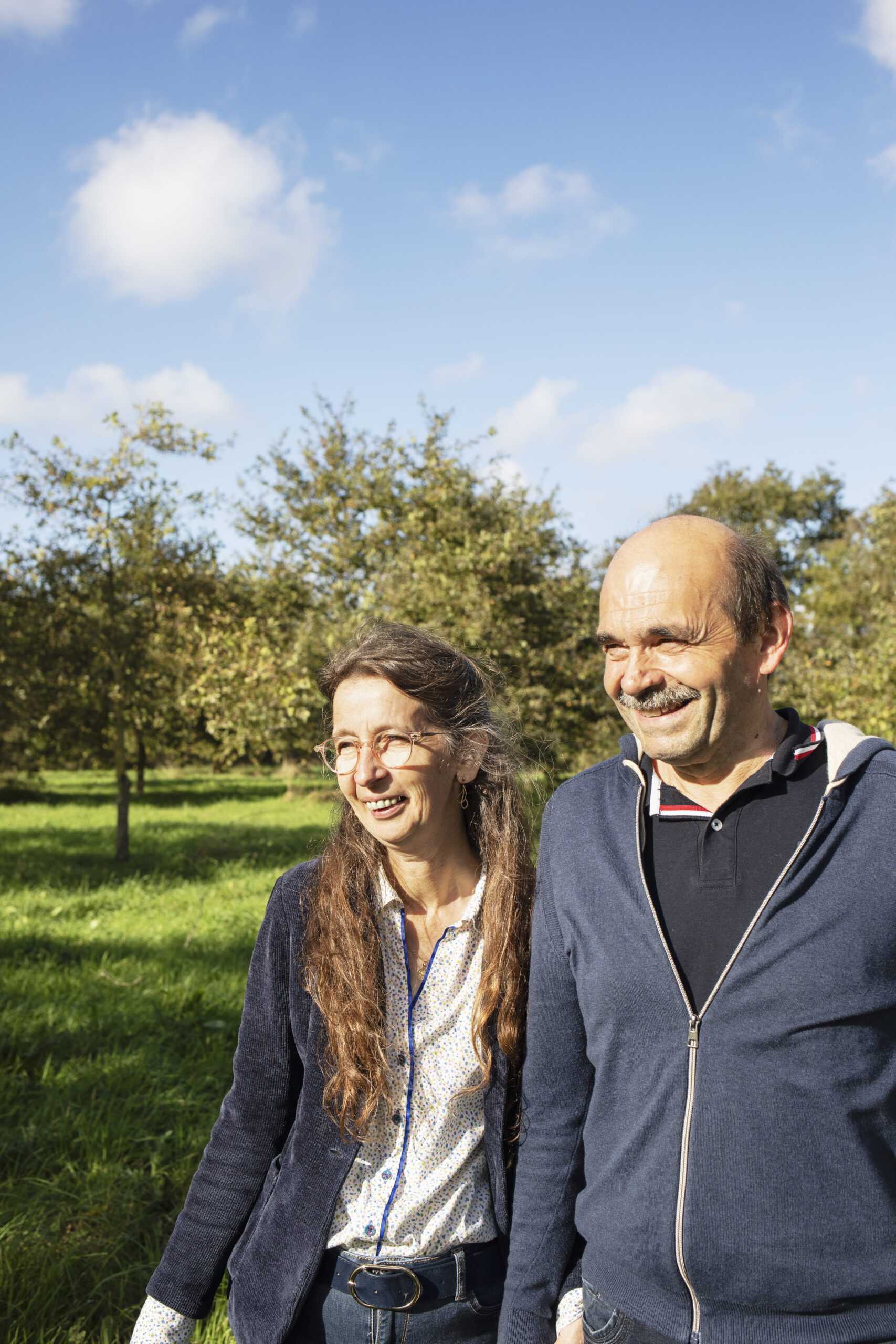 Portrait des éleveurs bio Hervé et Myriam, partenaires de Bodin, souriants dans un pré verdoyant.