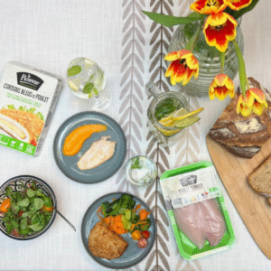 Table dressée avec produits bio Le Picoreur, poulet fermier, cordons bleus, légumes frais, pain et boisson maison.